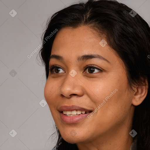 Joyful black young-adult female with long  brown hair and brown eyes