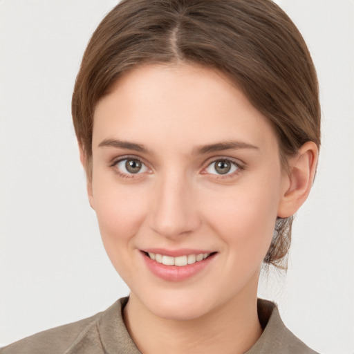 Joyful white young-adult female with short  brown hair and grey eyes