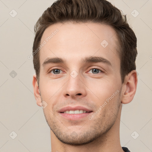 Joyful white young-adult male with short  brown hair and grey eyes