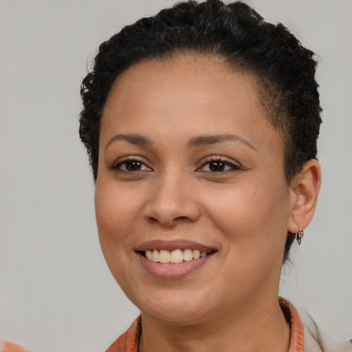Joyful black young-adult female with short  brown hair and brown eyes