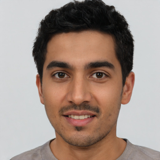 Joyful latino young-adult male with short  black hair and brown eyes