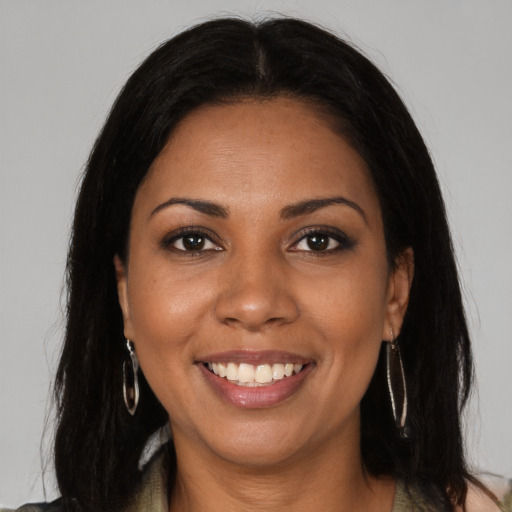 Joyful black young-adult female with long  brown hair and brown eyes
