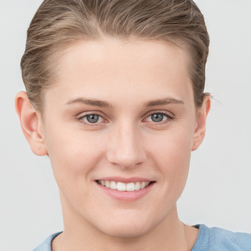 Joyful white young-adult female with short  brown hair and grey eyes