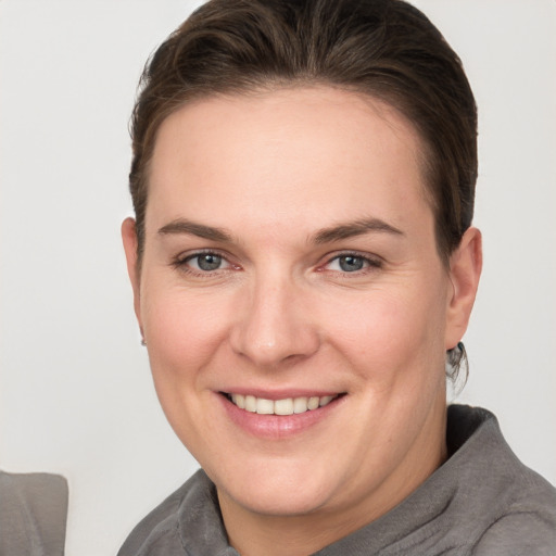 Joyful white young-adult female with short  brown hair and grey eyes