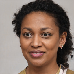 Joyful black adult female with medium  brown hair and brown eyes