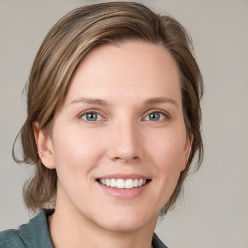 Joyful white young-adult female with medium  brown hair and blue eyes