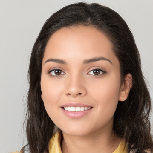 Joyful latino young-adult female with long  brown hair and brown eyes