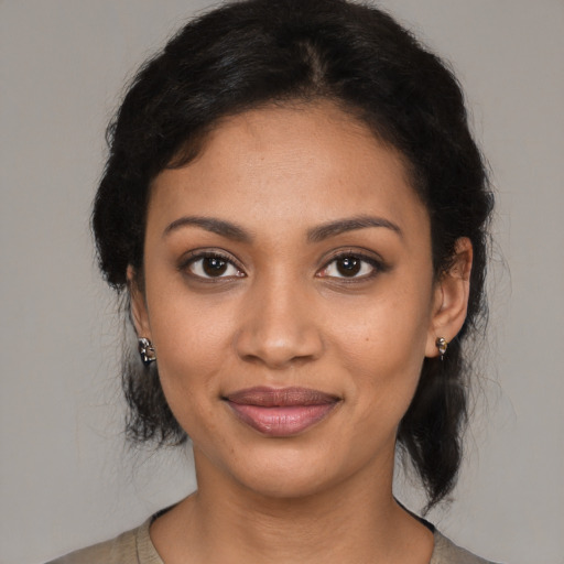 Joyful black young-adult female with medium  brown hair and brown eyes