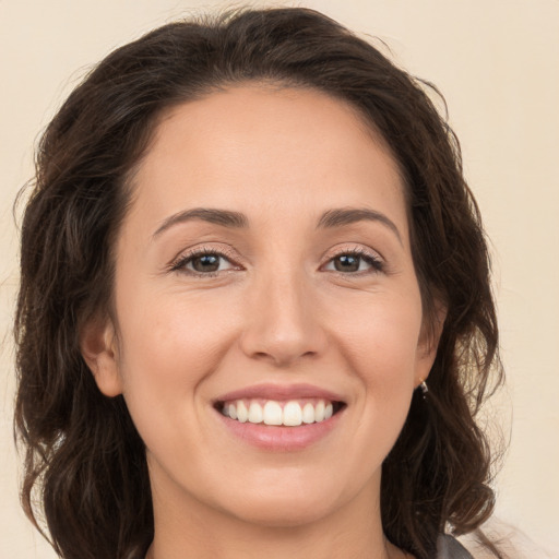 Joyful white young-adult female with long  brown hair and brown eyes