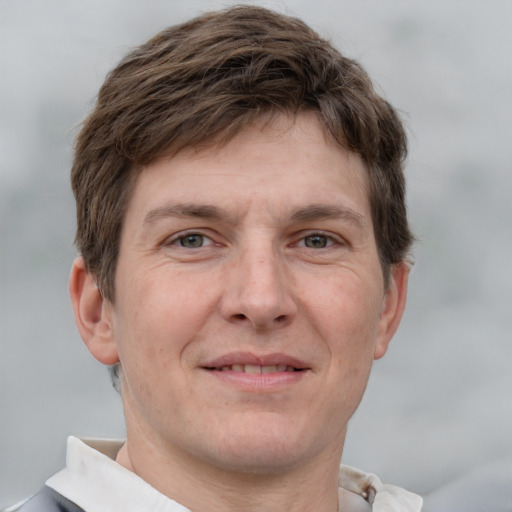 Joyful white adult male with short  brown hair and grey eyes