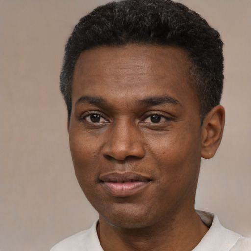 Joyful black young-adult male with short  black hair and brown eyes