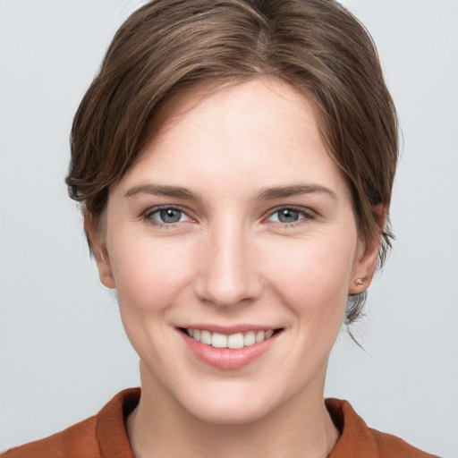 Joyful white young-adult female with medium  brown hair and grey eyes