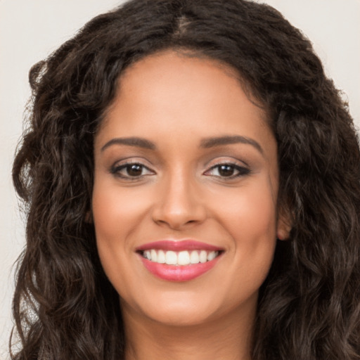 Joyful white young-adult female with long  brown hair and brown eyes