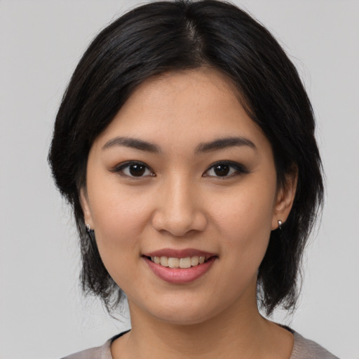Joyful asian young-adult female with medium  black hair and brown eyes