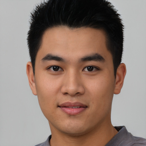 Joyful asian young-adult male with short  black hair and brown eyes