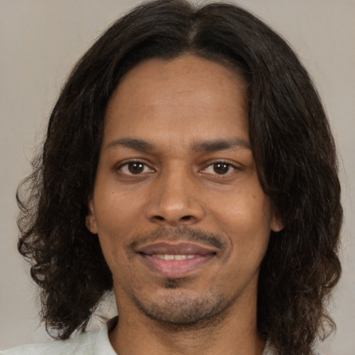Joyful black young-adult male with medium  brown hair and brown eyes