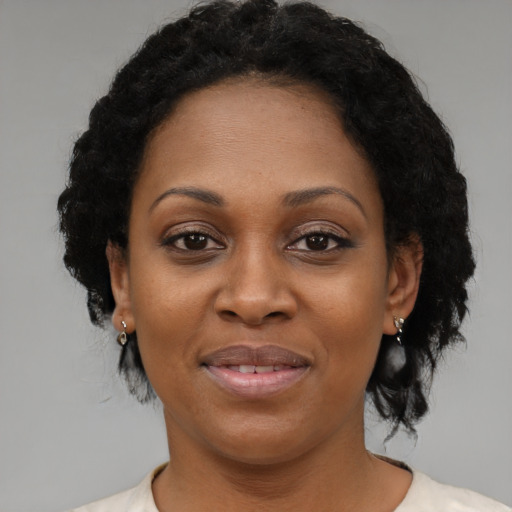 Joyful black adult female with short  black hair and brown eyes
