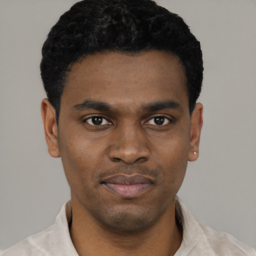 Joyful black young-adult male with short  black hair and brown eyes