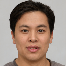 Joyful asian young-adult male with short  brown hair and brown eyes