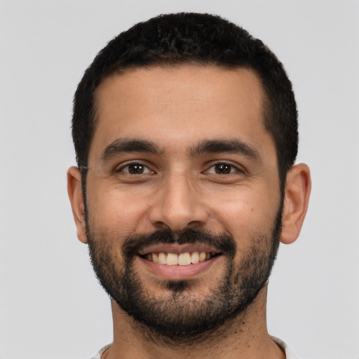 Joyful latino young-adult male with short  black hair and brown eyes