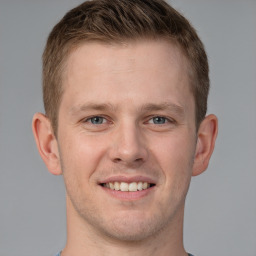 Joyful white young-adult male with short  brown hair and grey eyes