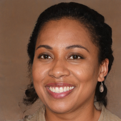 Joyful black adult female with medium  brown hair and brown eyes