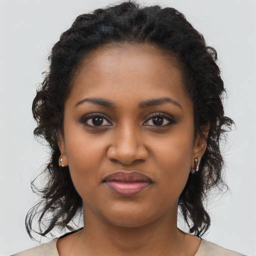 Joyful black young-adult female with long  brown hair and brown eyes