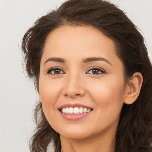 Joyful white young-adult female with long  brown hair and brown eyes