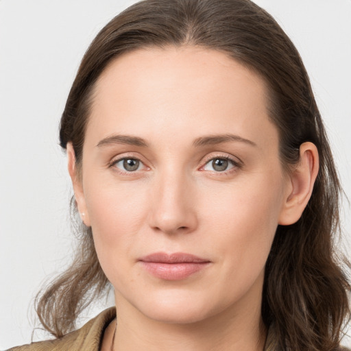 Joyful white young-adult female with long  brown hair and grey eyes