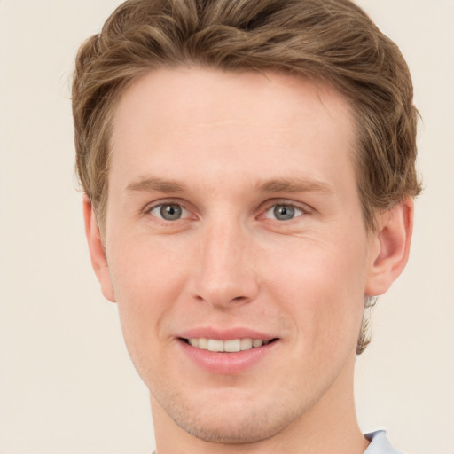 Joyful white young-adult male with short  brown hair and blue eyes