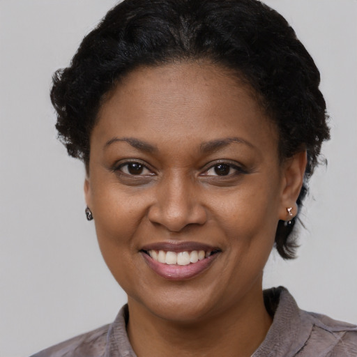 Joyful black young-adult female with short  brown hair and brown eyes
