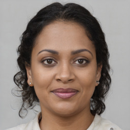 Joyful black young-adult female with long  brown hair and brown eyes