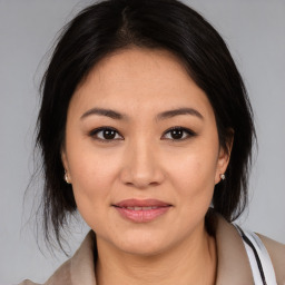 Joyful latino young-adult female with medium  brown hair and brown eyes