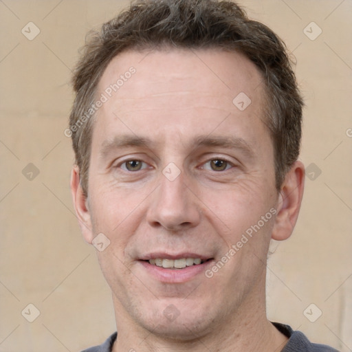 Joyful white adult male with short  brown hair and grey eyes