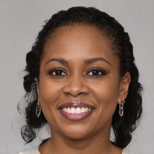 Joyful black adult female with medium  brown hair and brown eyes
