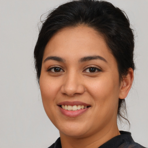 Joyful latino young-adult female with medium  brown hair and brown eyes