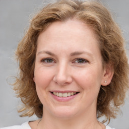 Joyful white young-adult female with medium  brown hair and blue eyes