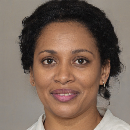 Joyful black adult female with short  black hair and brown eyes