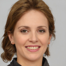 Joyful white young-adult female with medium  brown hair and green eyes