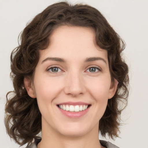 Joyful white young-adult female with medium  brown hair and green eyes