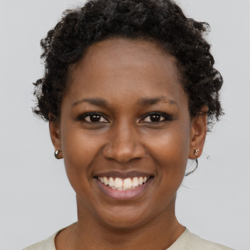 Joyful black young-adult female with short  brown hair and brown eyes