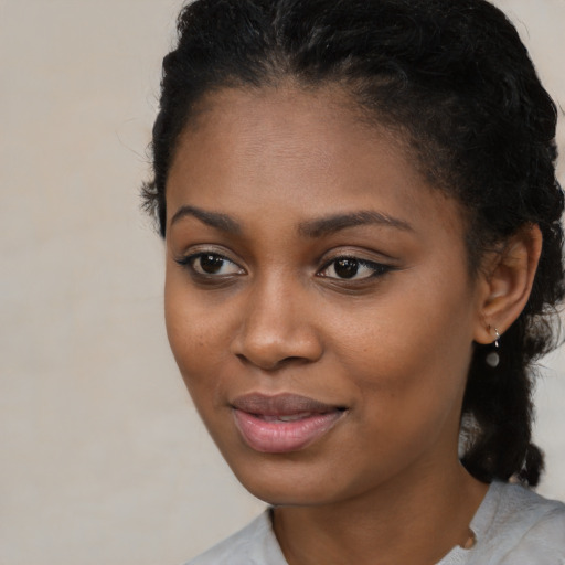 Joyful black young-adult female with medium  black hair and brown eyes
