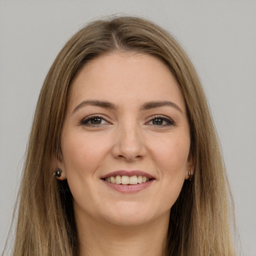 Joyful white young-adult female with long  brown hair and brown eyes