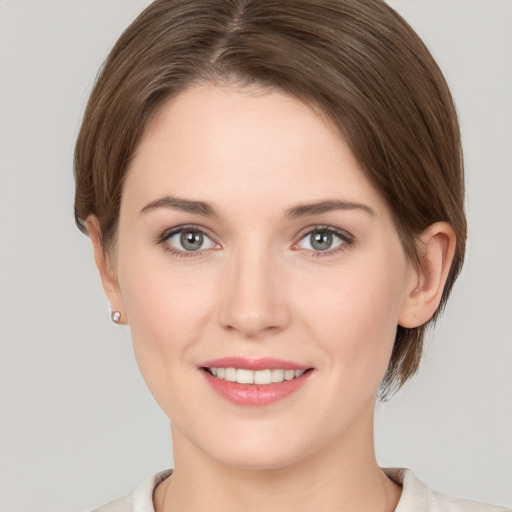 Joyful white young-adult female with medium  brown hair and grey eyes