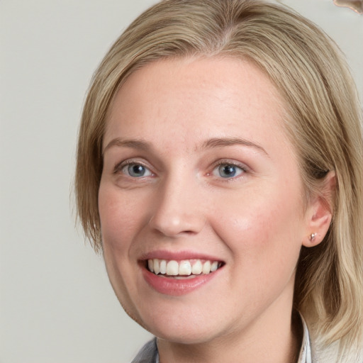 Joyful white young-adult female with medium  brown hair and blue eyes