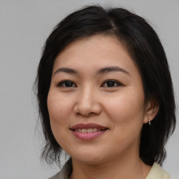 Joyful asian young-adult female with medium  brown hair and brown eyes