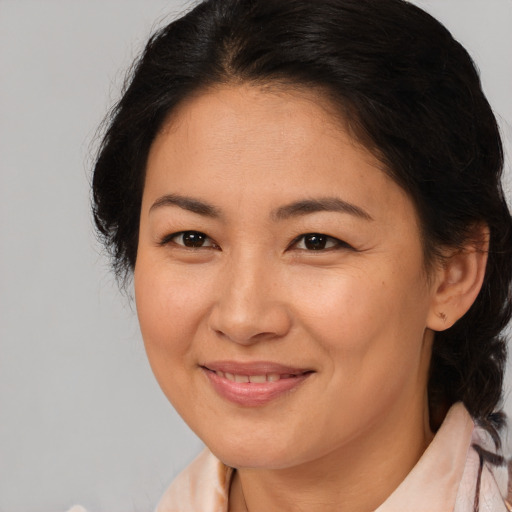 Joyful latino adult female with medium  brown hair and brown eyes