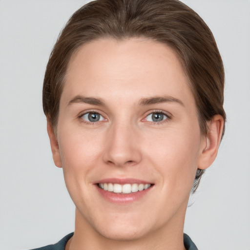 Joyful white young-adult female with short  brown hair and grey eyes