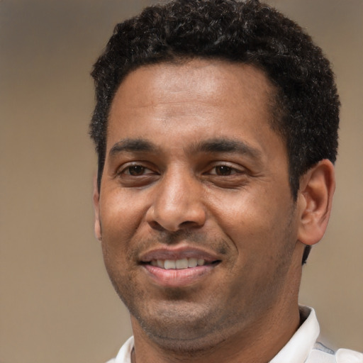 Joyful black young-adult male with short  brown hair and brown eyes