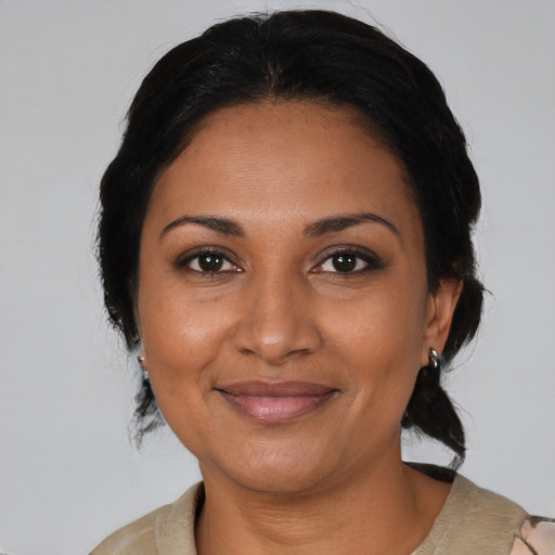Joyful black adult female with medium  brown hair and brown eyes